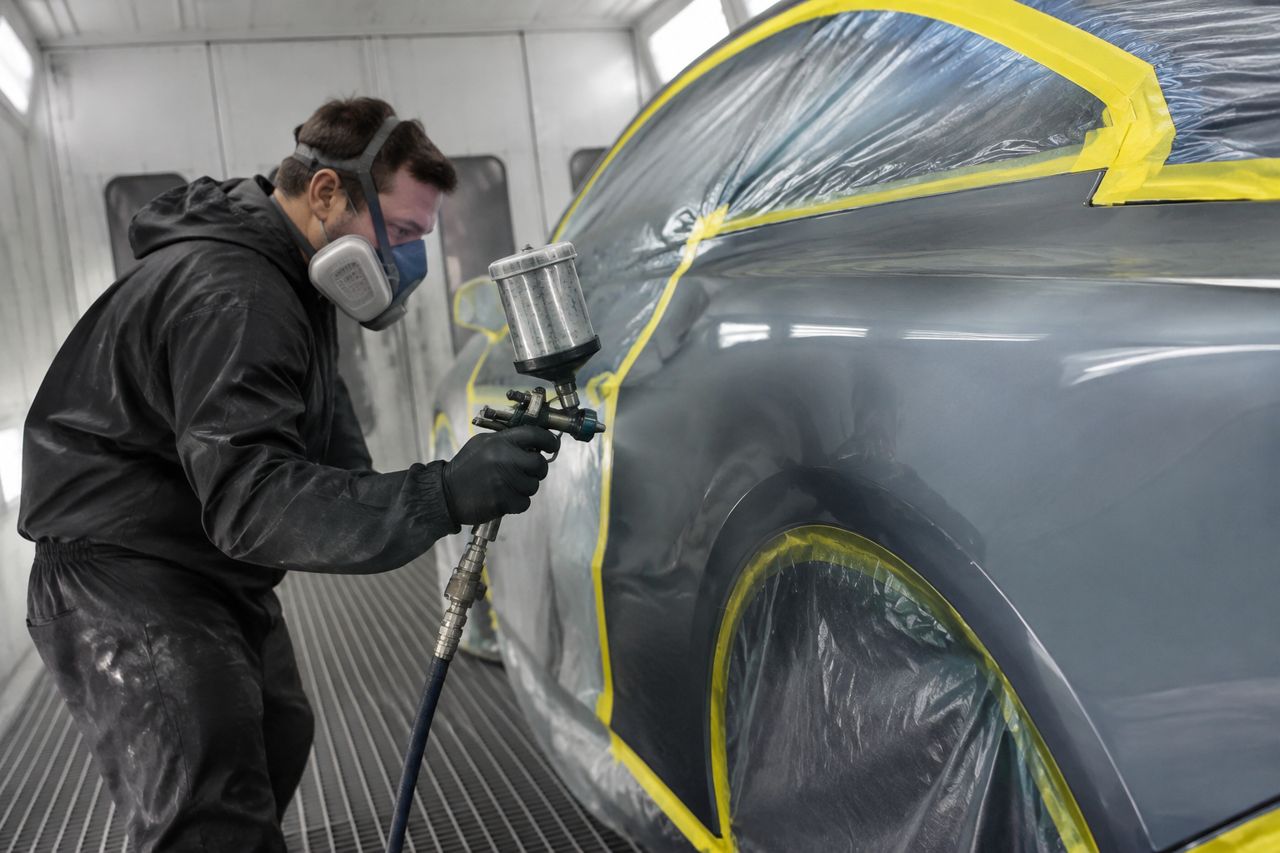 Auto body painter in a booth